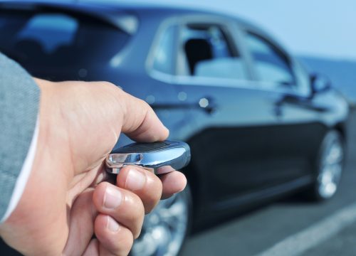 detail of a man in suit opening his car with the control remote key